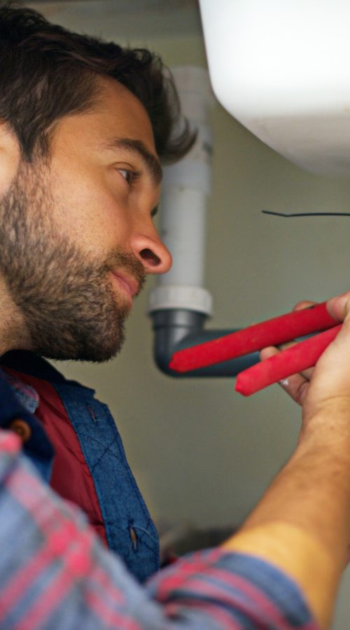 Hes a pro at plumbing. Shot of a plumber fixing a pipe.